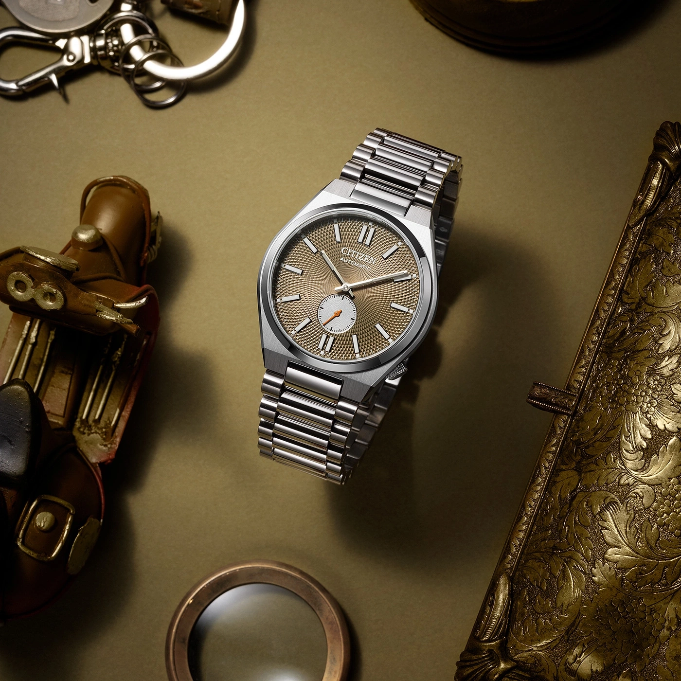 Citizen watch with a gold face, surrounded by vintage accessories.