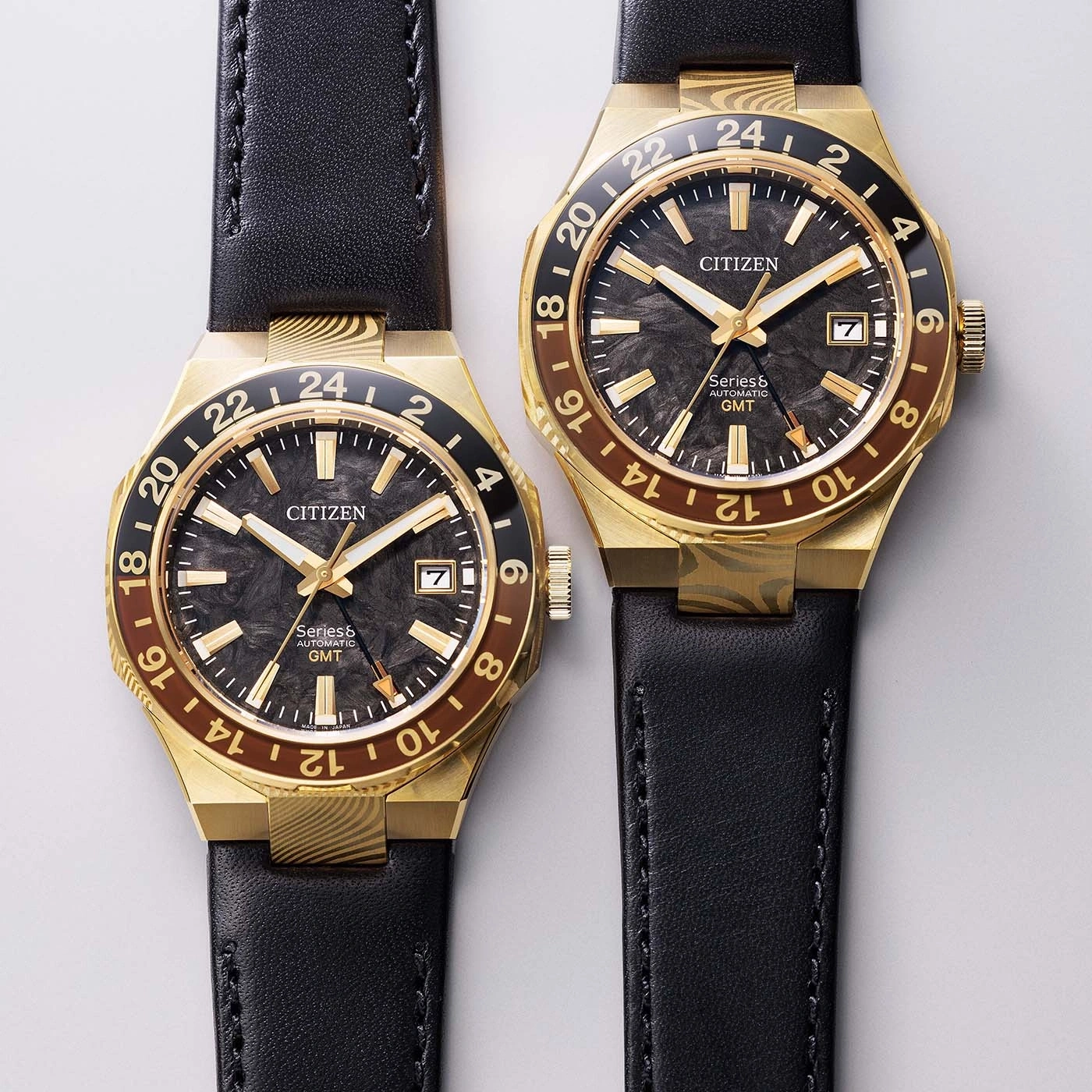 Two gold Citizen GMT watches with black leather straps
