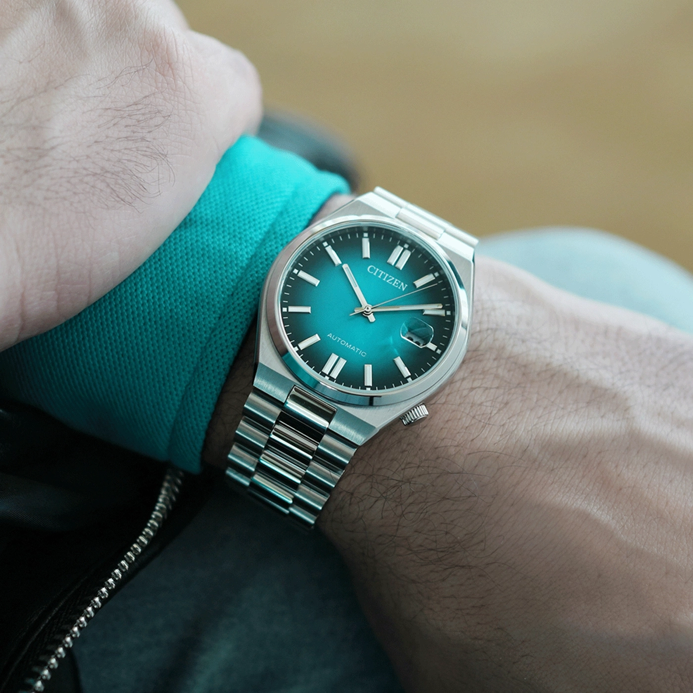Citizen watch on wrist, teal dial, silver bracelet, automatic movement
