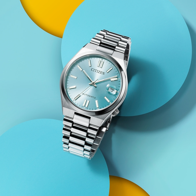 Citizen watch with a light blue face on a colorful background.