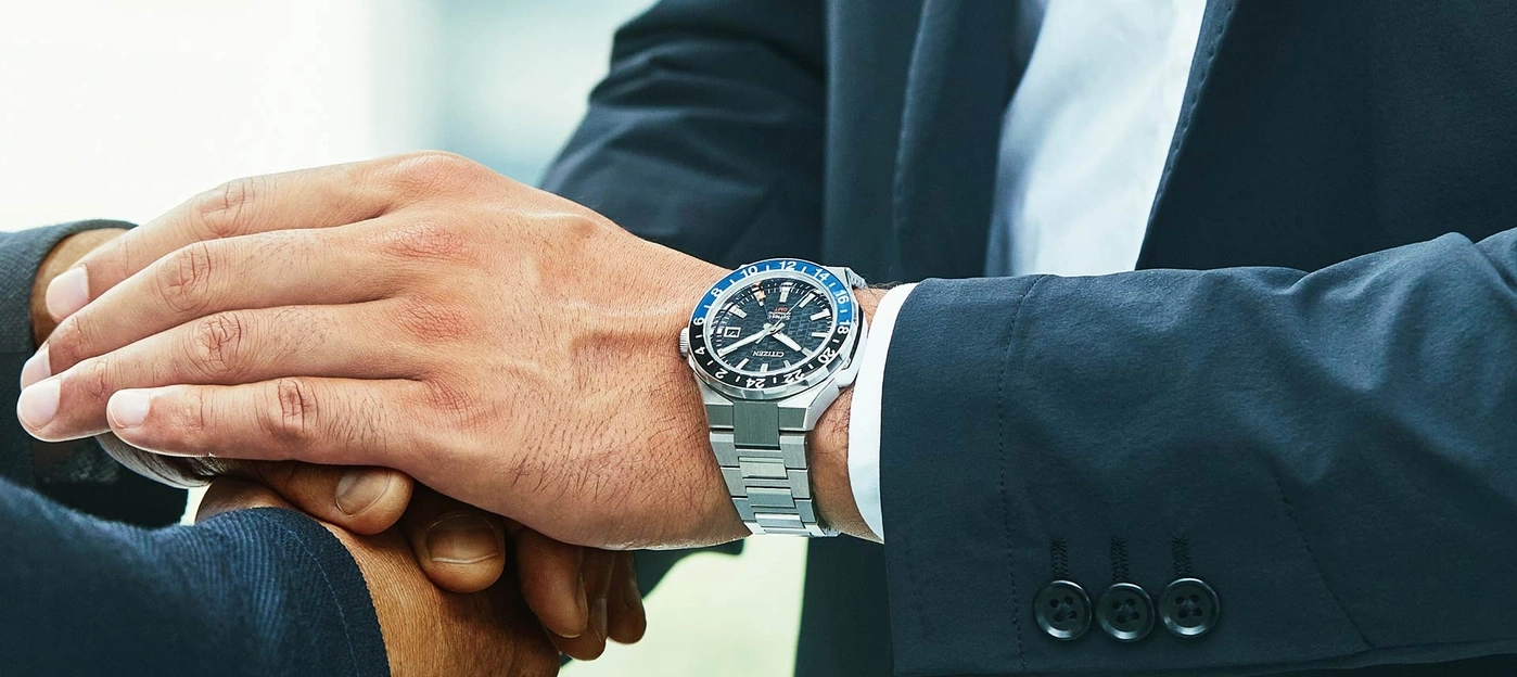 Man wearing a watch, shaking hands, business attire, close-up shot, deal