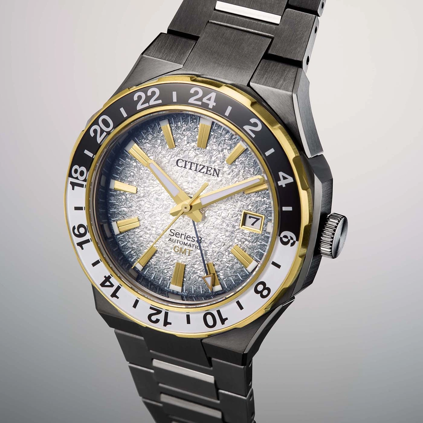 Citizen watch with gold accents, black bezel, and textured silver dial.