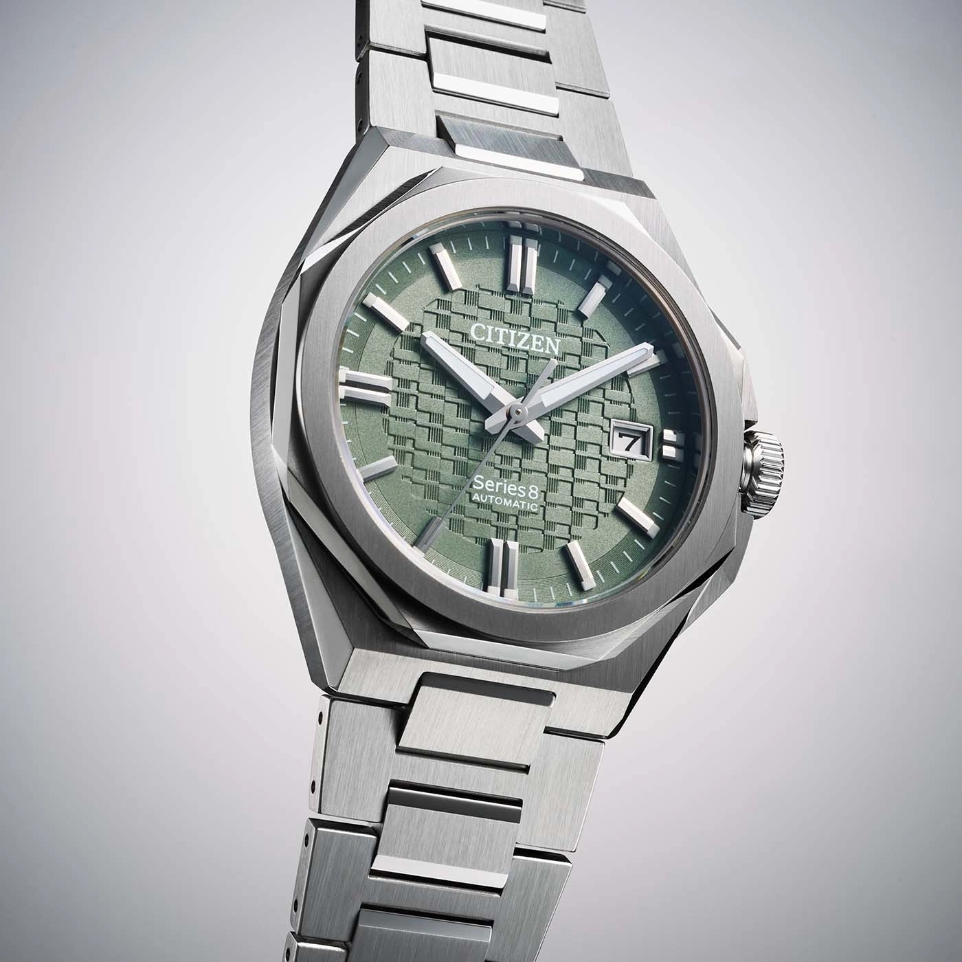 A close-up studio shot of a Citizen Series 8 automatic watch with a green textured dial and stainless steel bracelet.