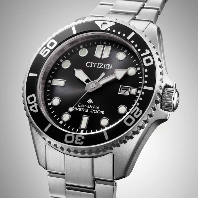 Citizen watch with black dial and silver bracelet, close-up shot.