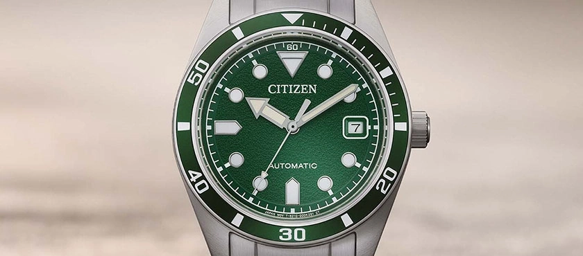 Close-up of a green Citizen automatic watch with a date window.