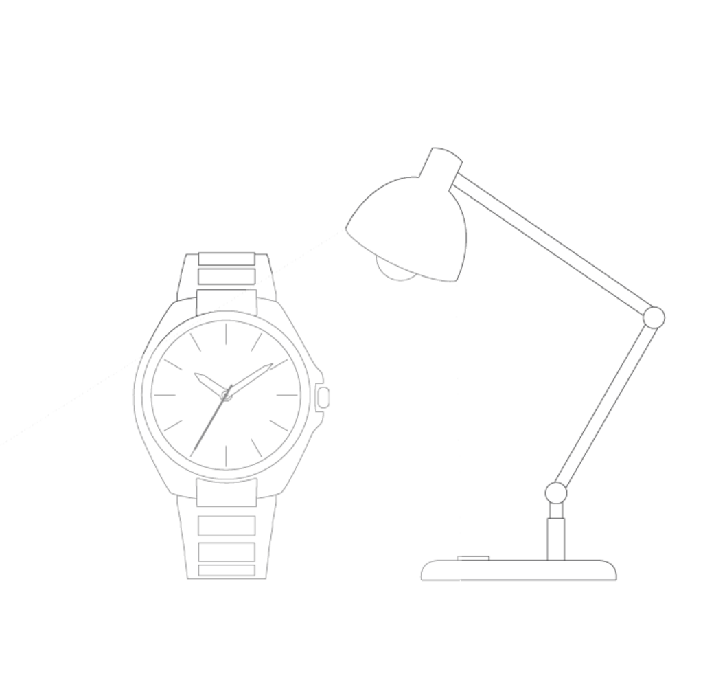 Watch illuminated by a desk lamp, showing the time on its face.