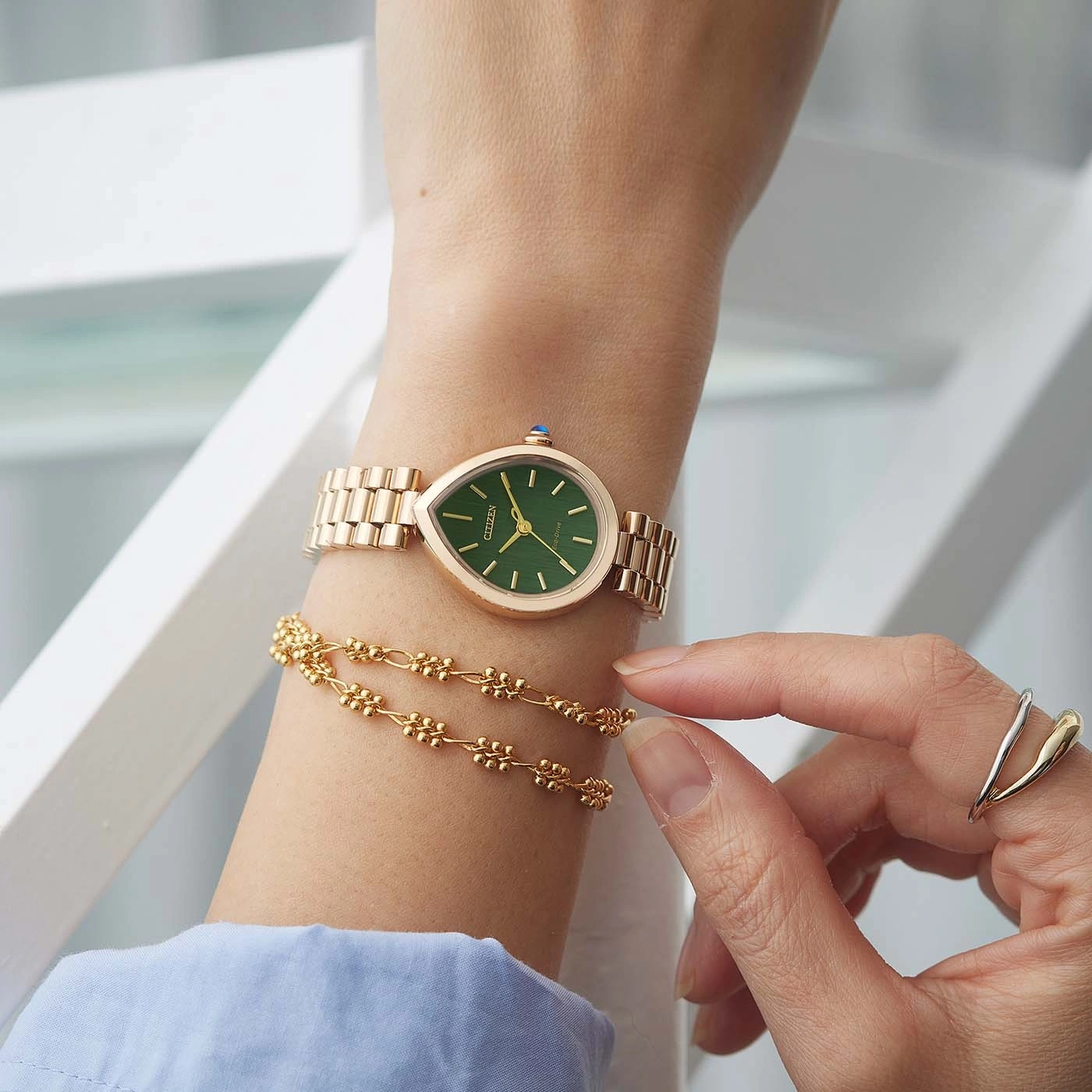 A woman's wrist with a rose gold watch and bracelet.