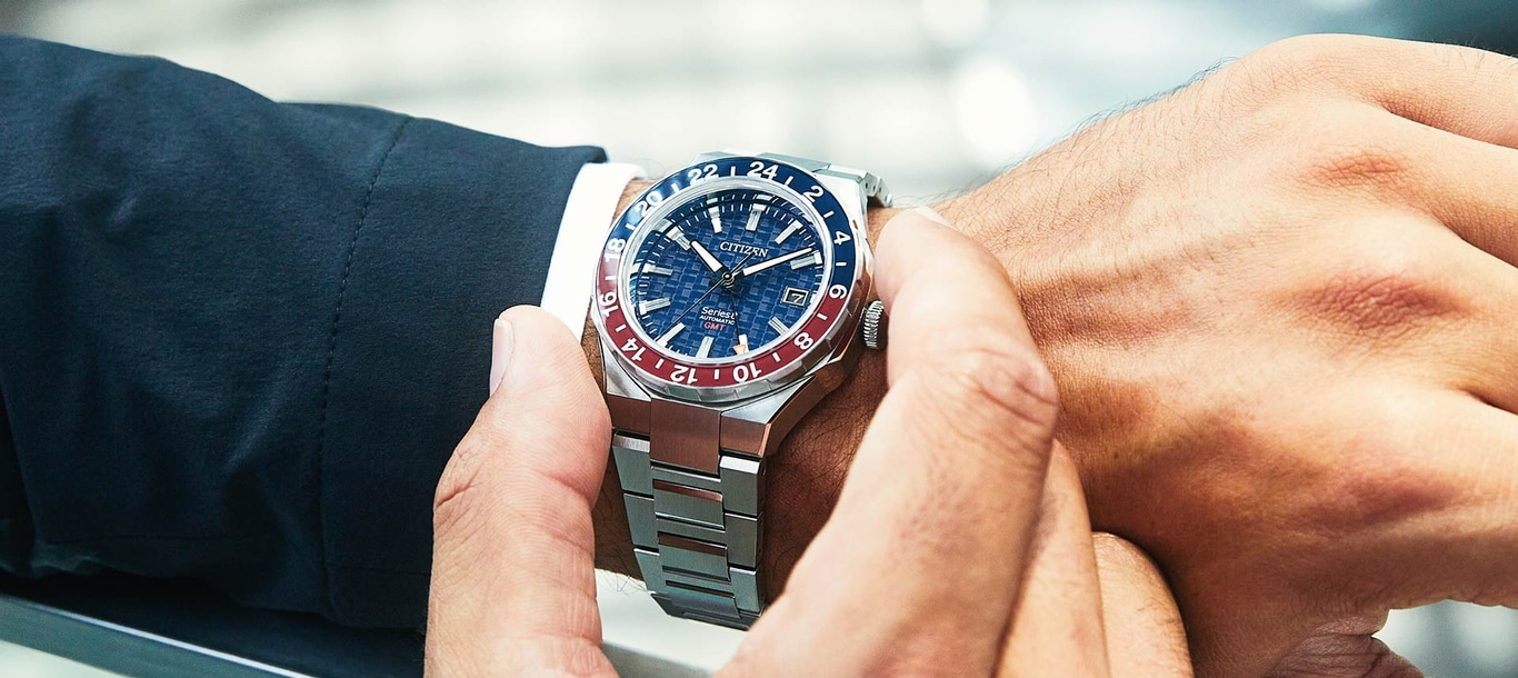 Close-up of a man's wrist with a Citizen watch, showing the watch's details.