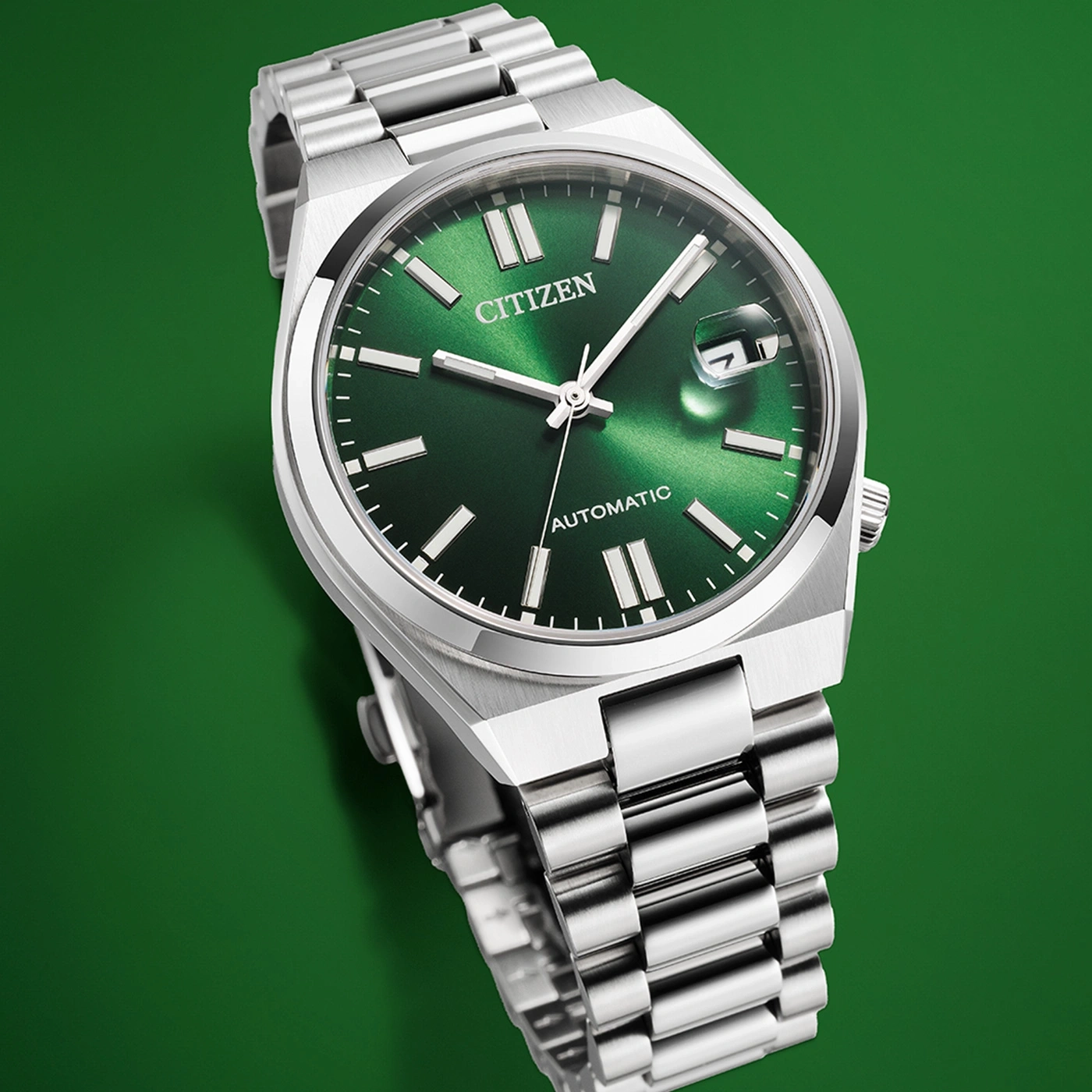 Citizen watch with green face and silver band on a green background.