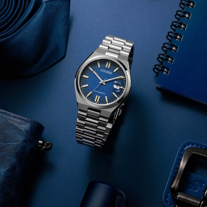 Citizen watch on blue surface with accessories, close-up shot, elegant