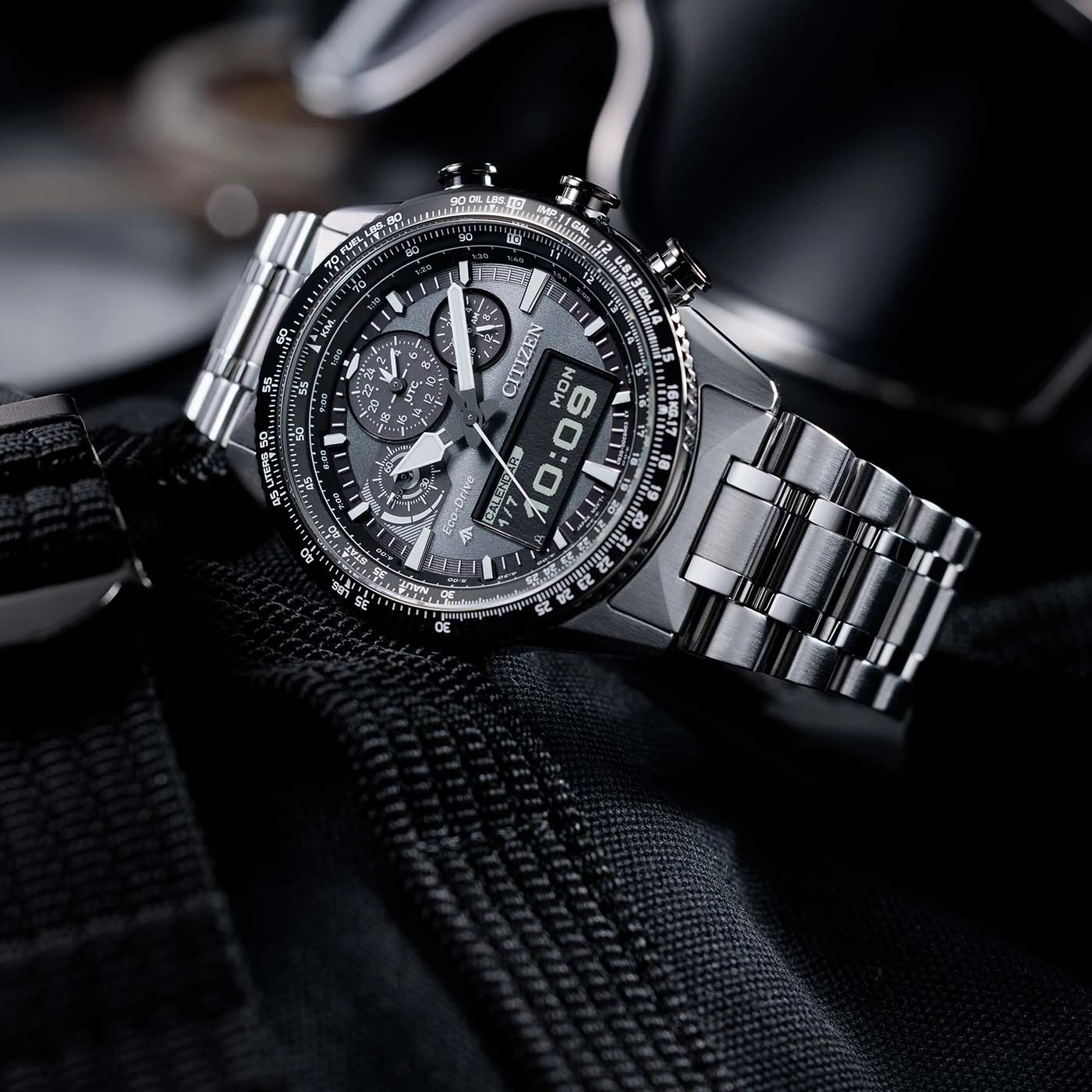 Citizen watch with a digital display, stainless steel band, and chronograph features.