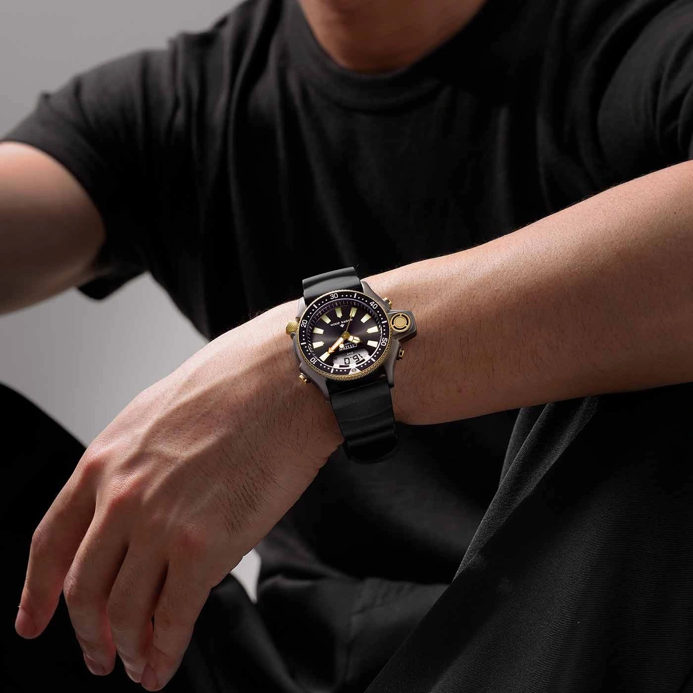 Man wearing a black watch with a black strap and gold accents.
