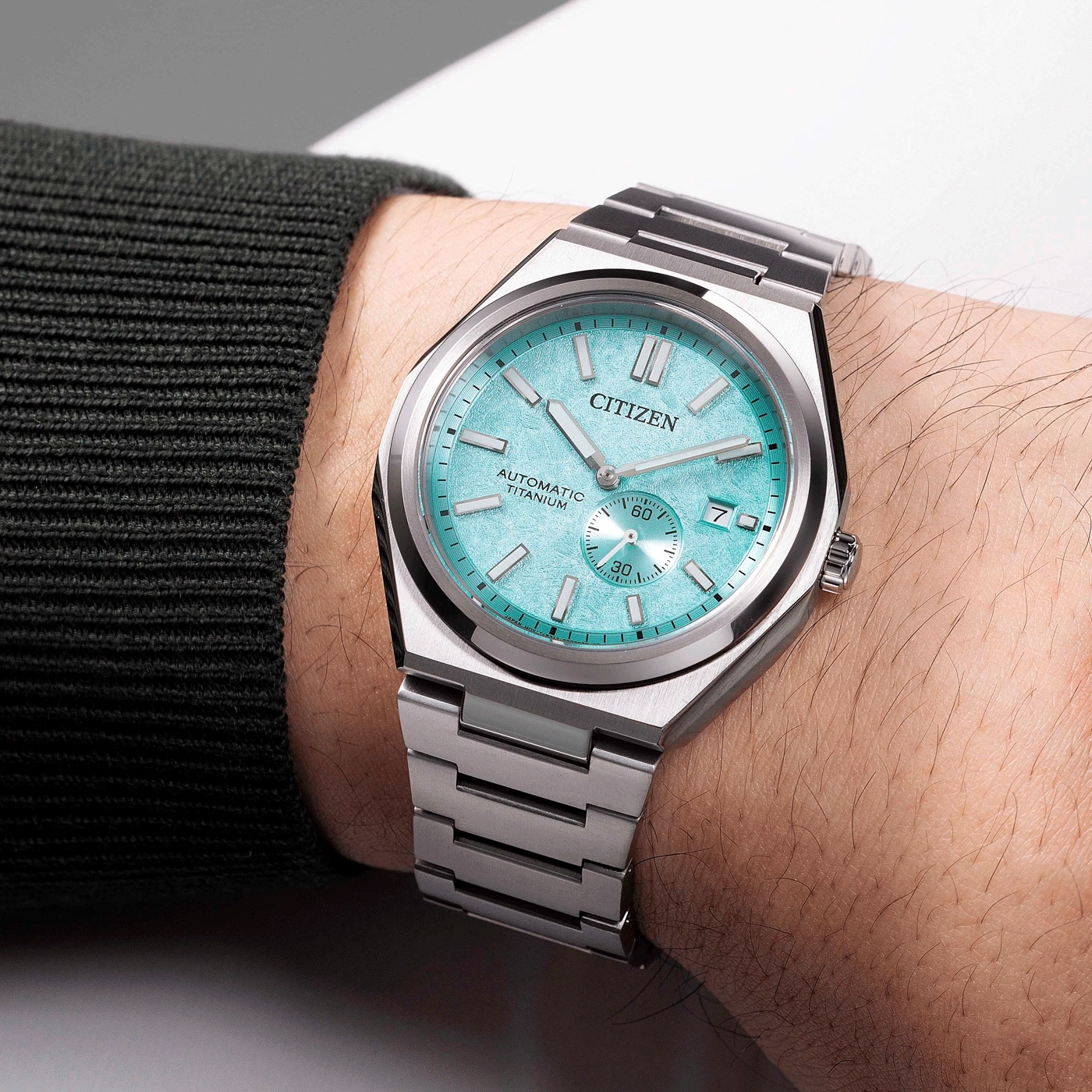 Citizen watch on wrist, turquoise face, automatic titanium, silver bracelet, close-up