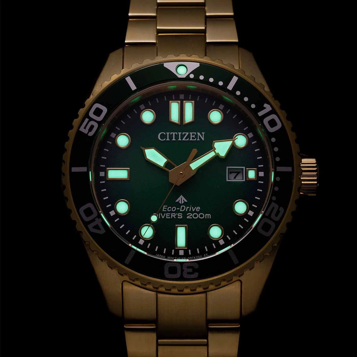 Citizen watch with green face and gold band, glowing in the dark.