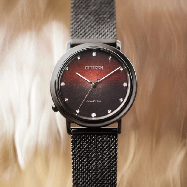 Citizen watch with a black strap and a red and black face.