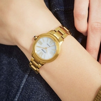 Gold Citizen watch on wrist, white face, Roman numerals, gold bracelet, close-up