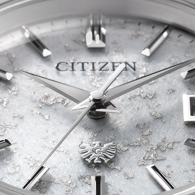 Close-up of a Citizen watch face with silver accents and logo.