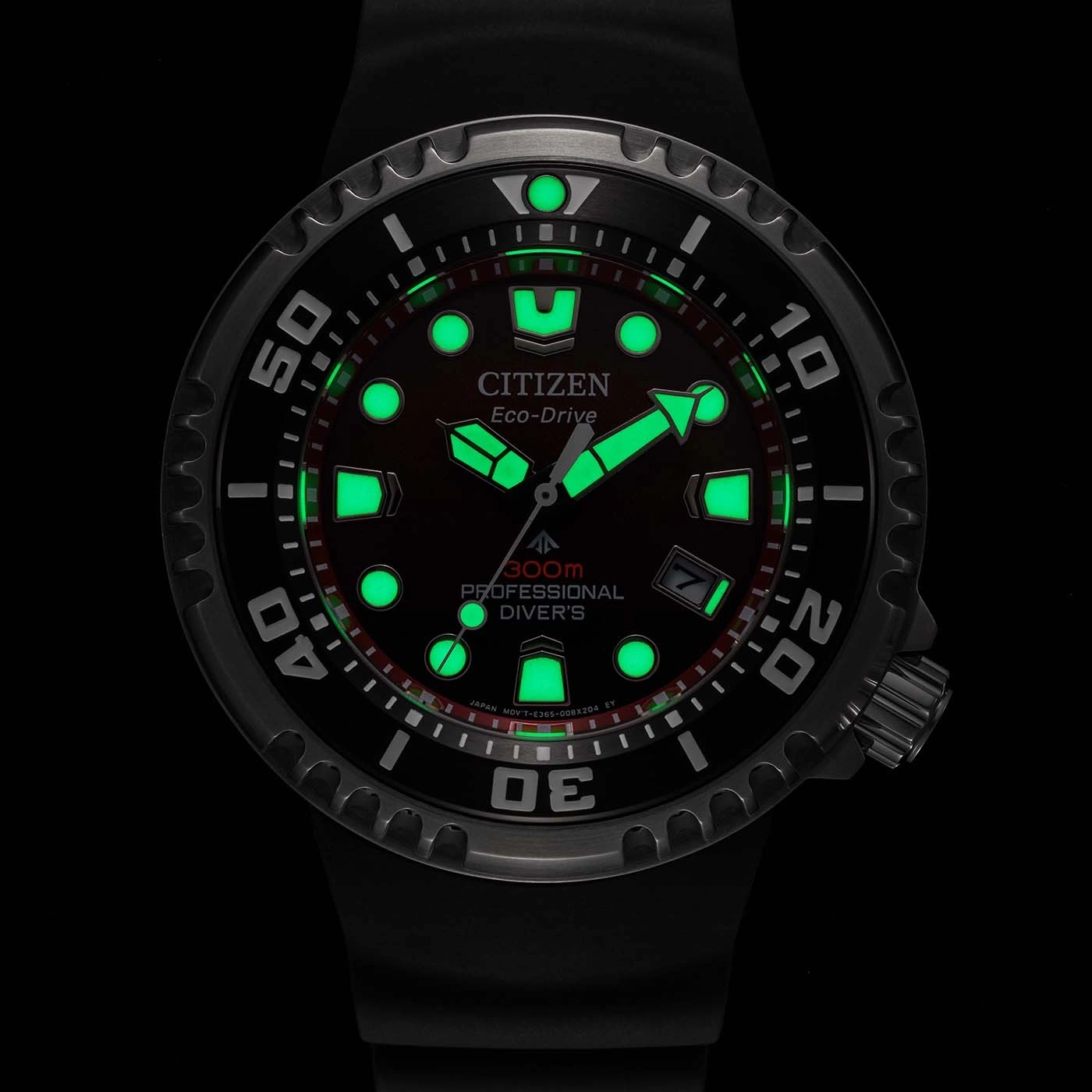 Citizen Eco-Drive watch with glowing green elements, black background, professional diver's watch.