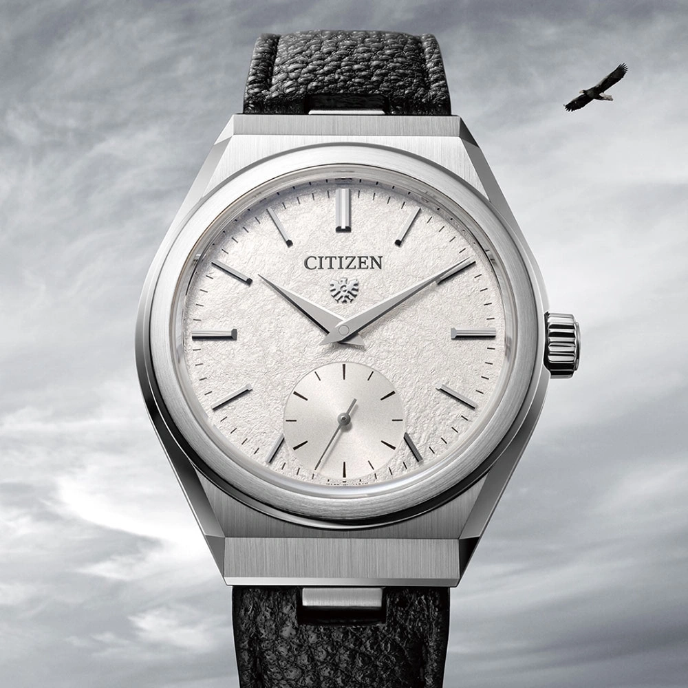 Citizen watch with a textured face and black leather strap, eagle in background.
