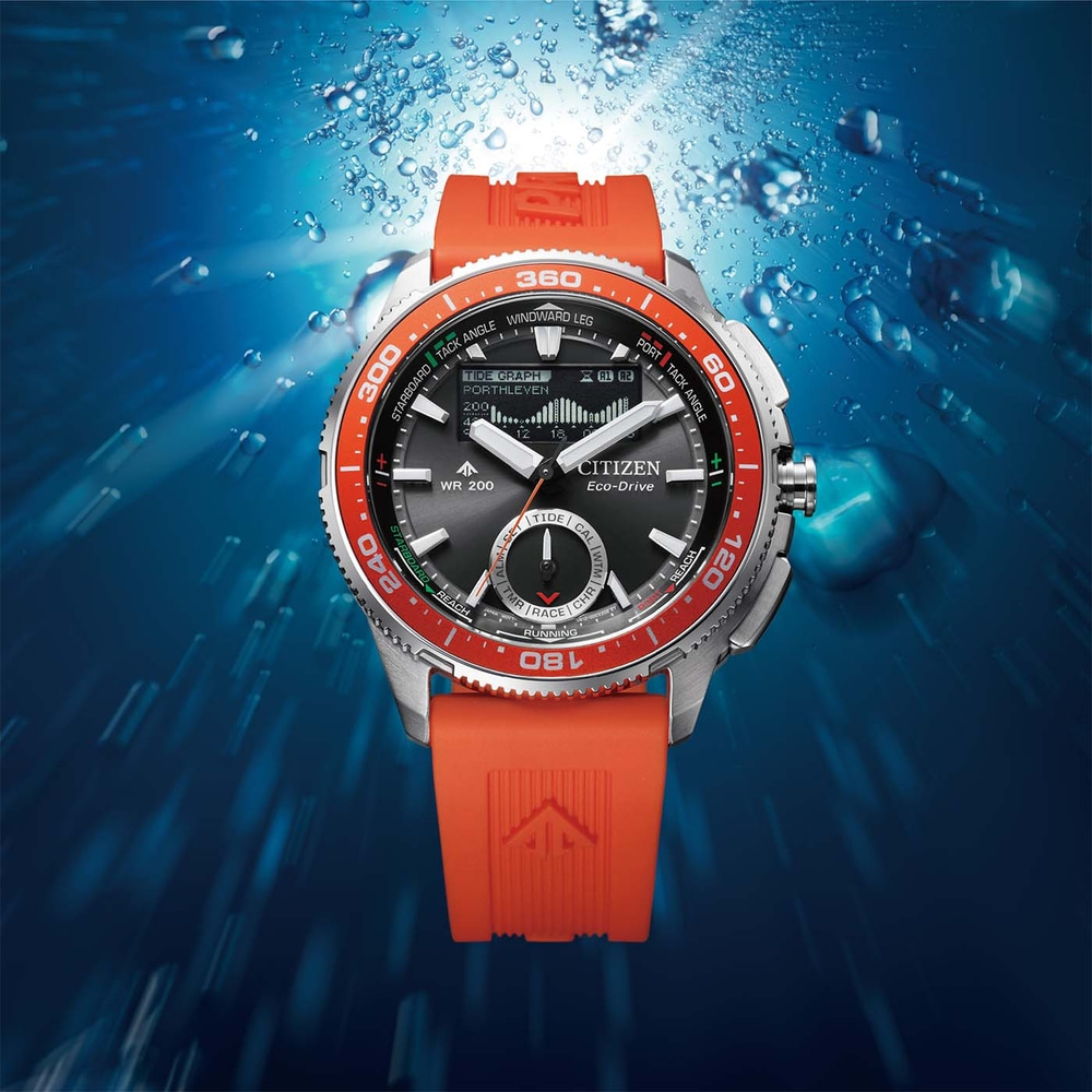 A diving watch with an orange strap in blue water.