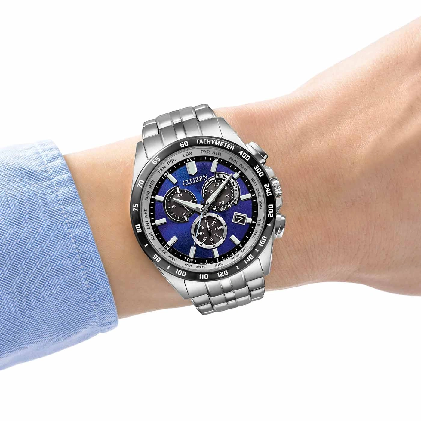 Citizen watch on wrist, blue face, silver band, chronograph, tachymeter, time display.