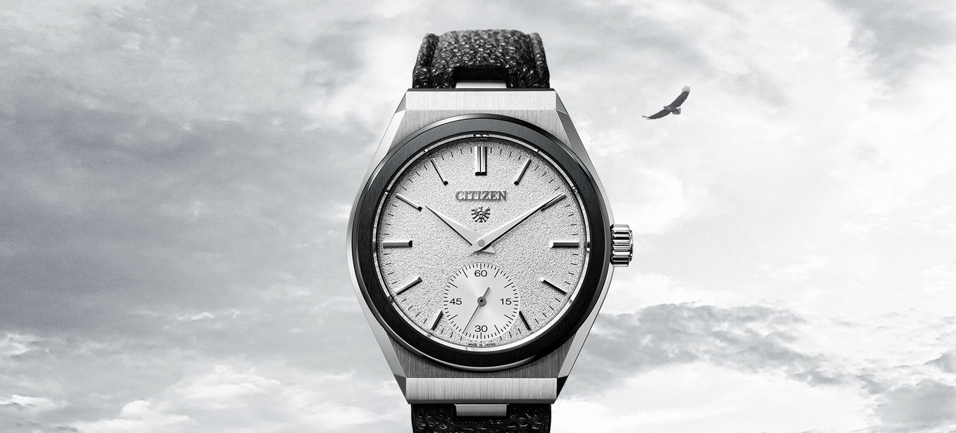 Citizen watch with a textured face and a black leather strap, with an eagle in the sky.