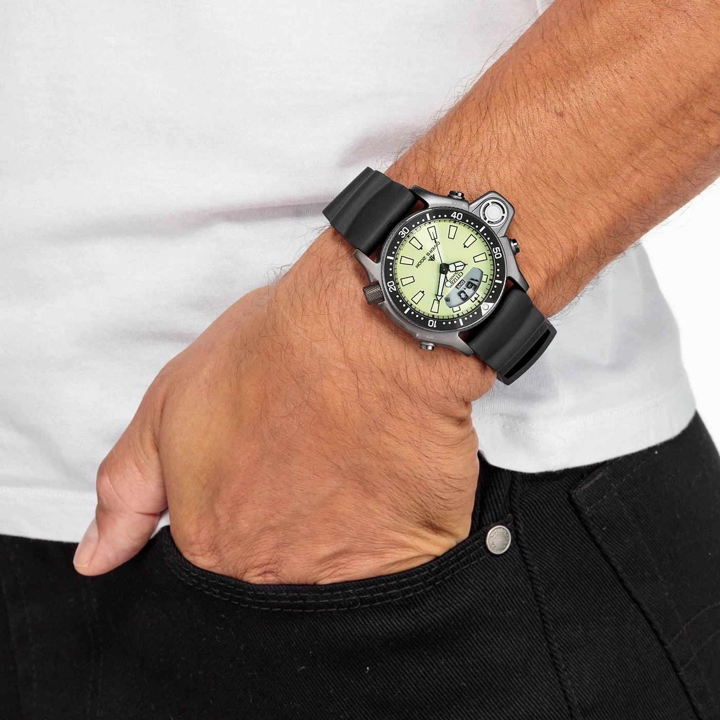 Man wearing a watch, hand in pocket, black jeans, white shirt.