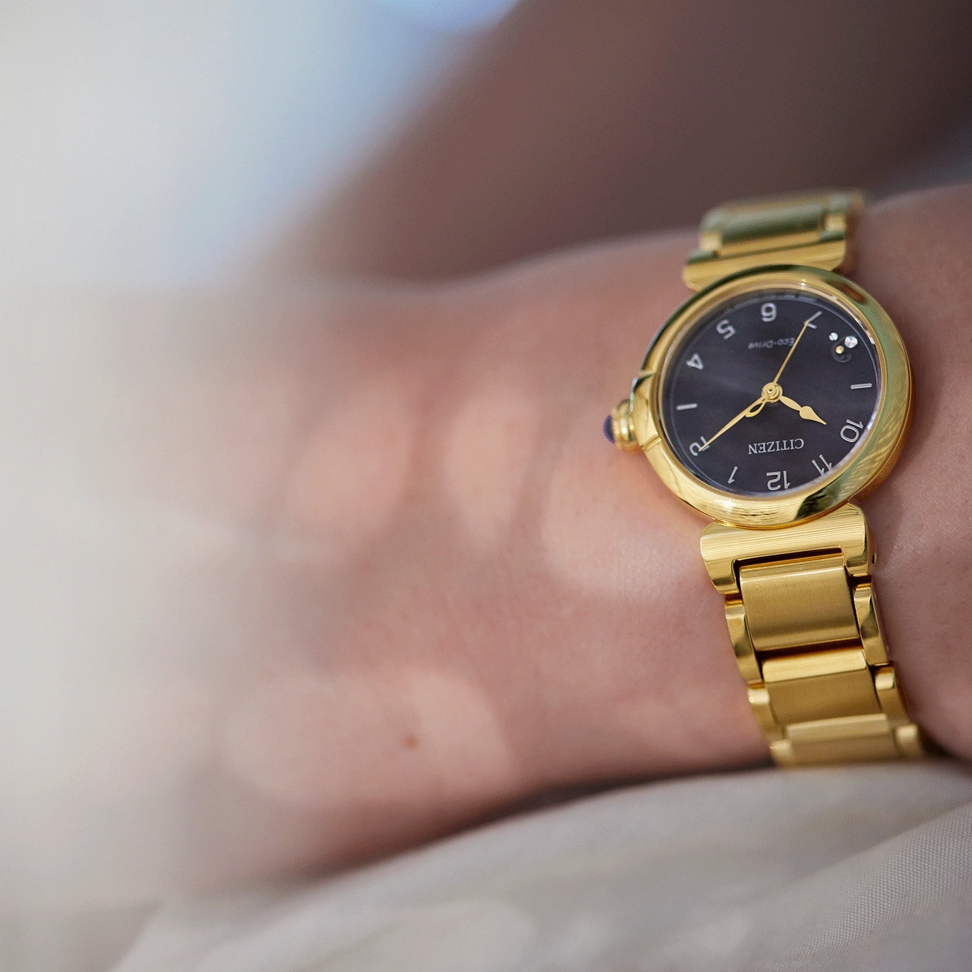 Close-up of a gold Citizen watch on a wrist, elegant and stylish.