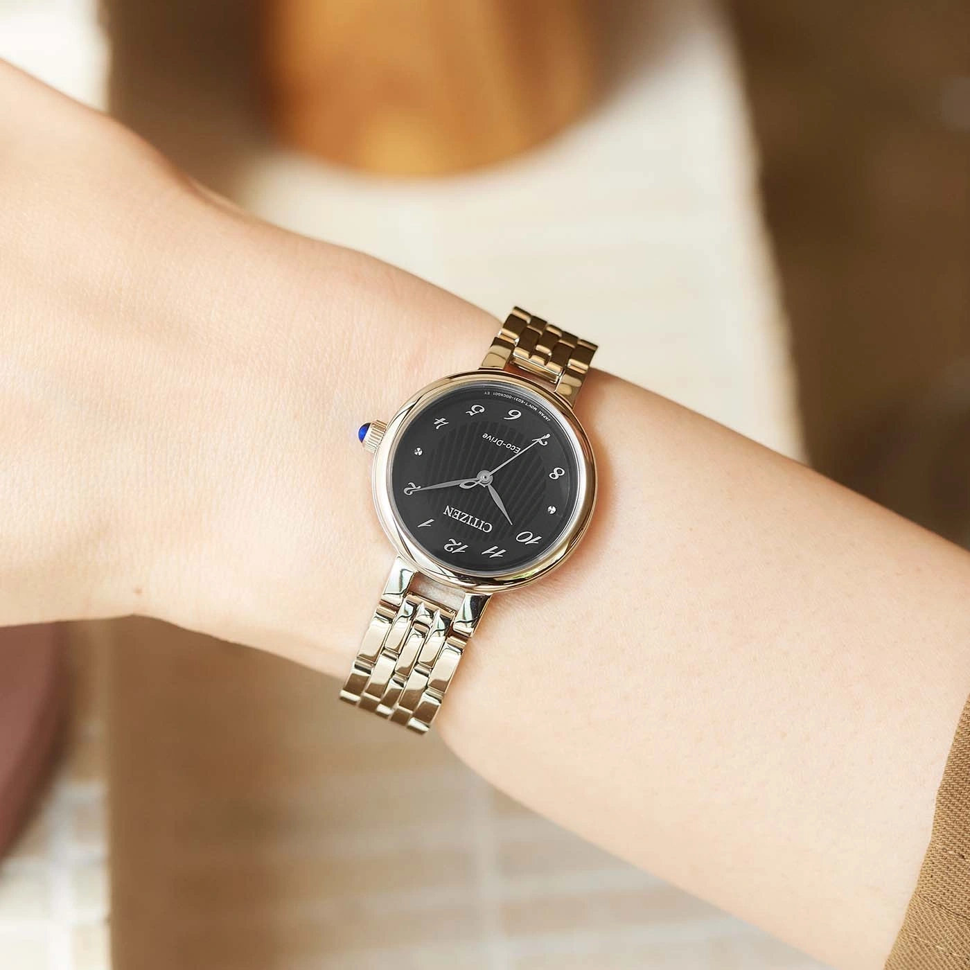 Wrist watch on a wrist, black face, silver band, Citizen Eco-Drive, elegant.