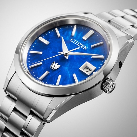 Citizen-Uhr mit blauem Zifferblatt, silbernem Armband und Datumsanzeige bei 3 Uhr.