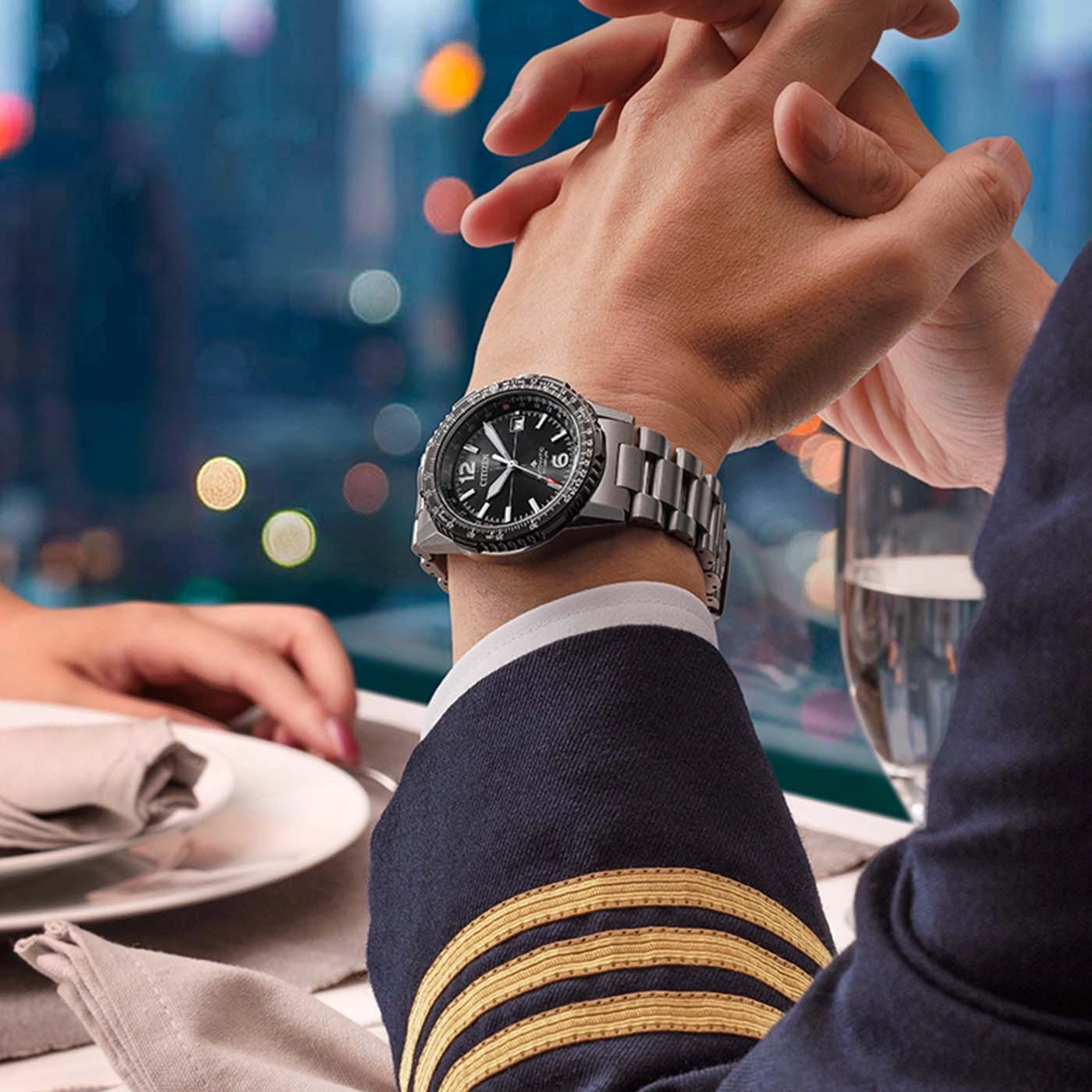 Man wearing a pilot uniform and a watch, holding hands