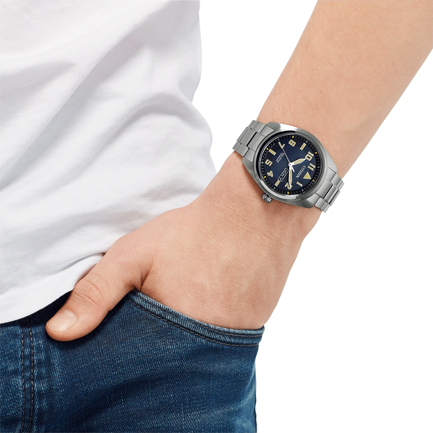Man wearing a Citizen watch, blue dial, stainless steel bracelet, jeans and white shirt.