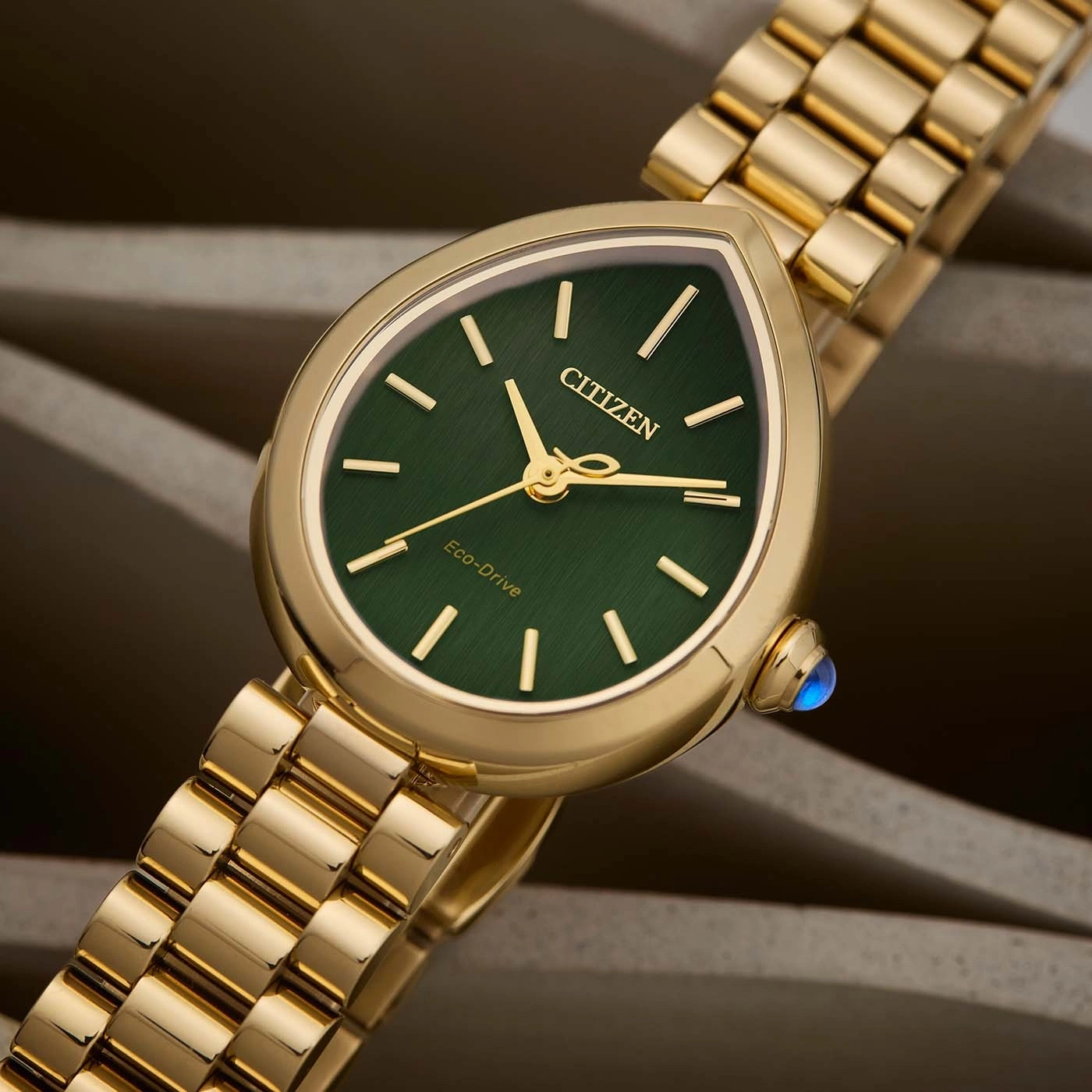 A gold Citizen Eco-Drive watch with a green dial.