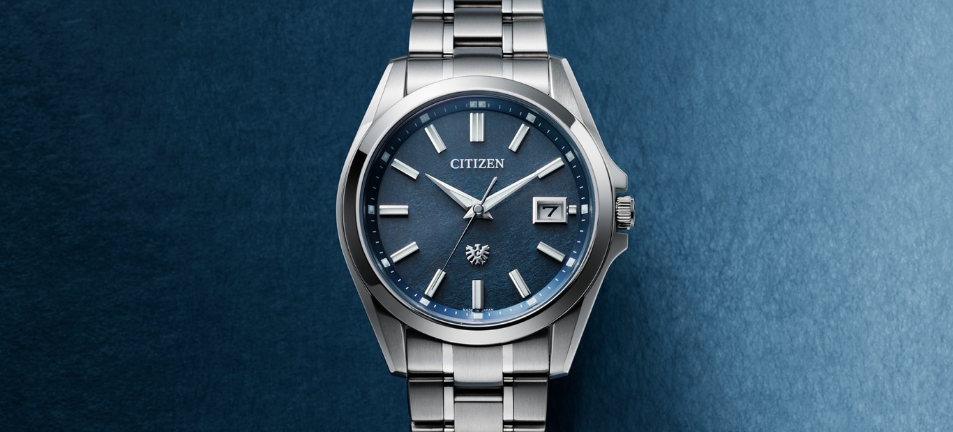 Citizen-Uhr mit blauem Zifferblatt und silbernem Armband auf blauem Hintergrund