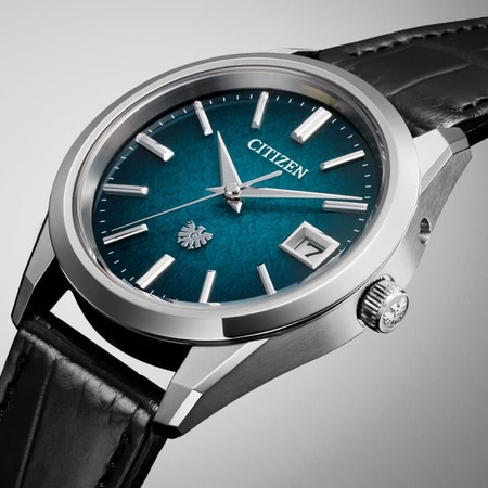 Citizen-Uhr mit tealfarbenem Zifferblatt, silbernem Gehäuse und schwarzem Lederarmband.