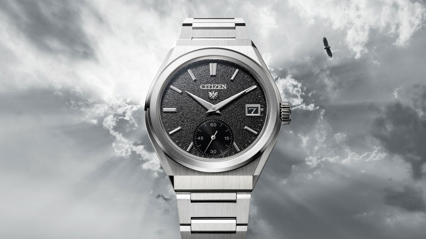 Citizen watch with black face, silver band, and eagle in the sky.
