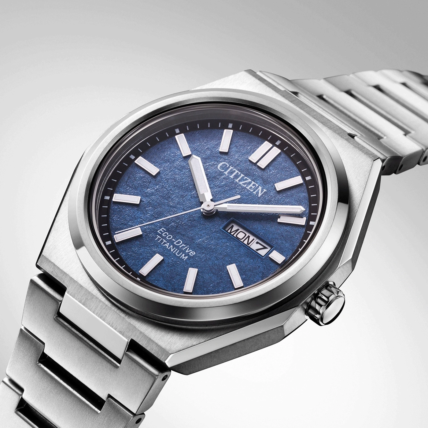 Citizen watch with blue face and titanium band, close-up shot.