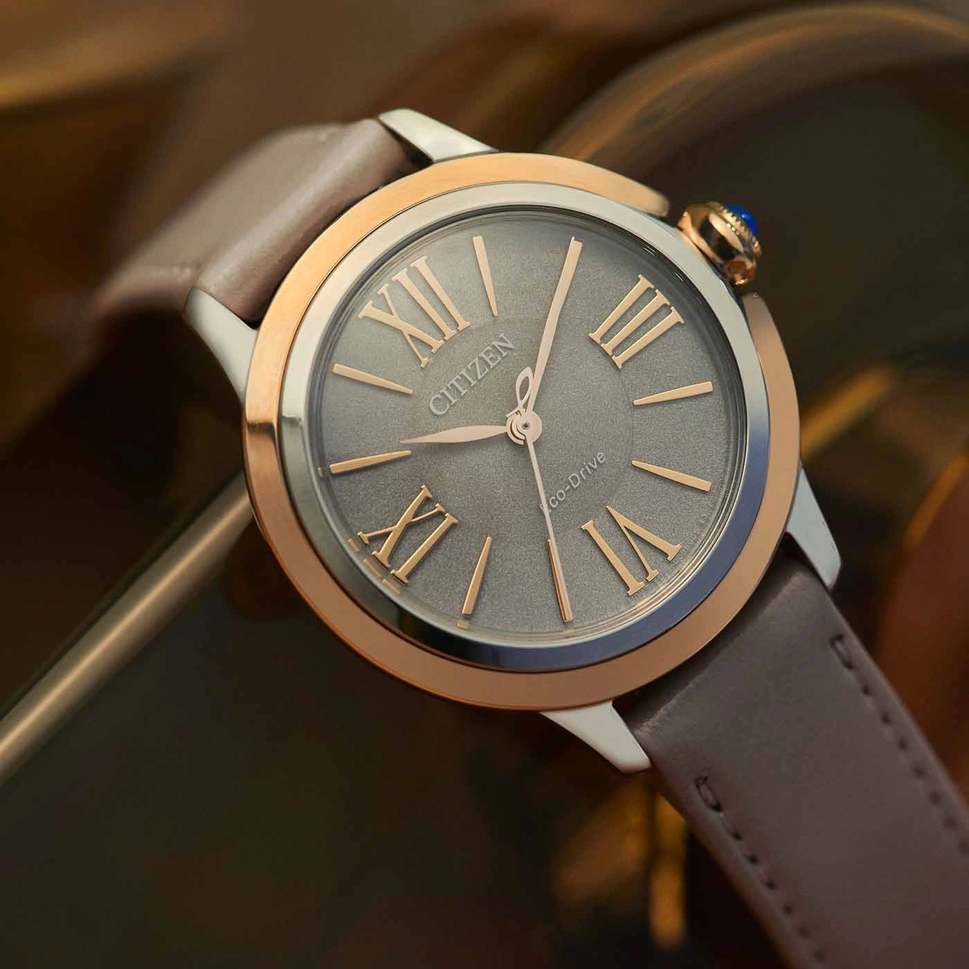 Citizen watch with grey face, roman numerals, and leather strap.