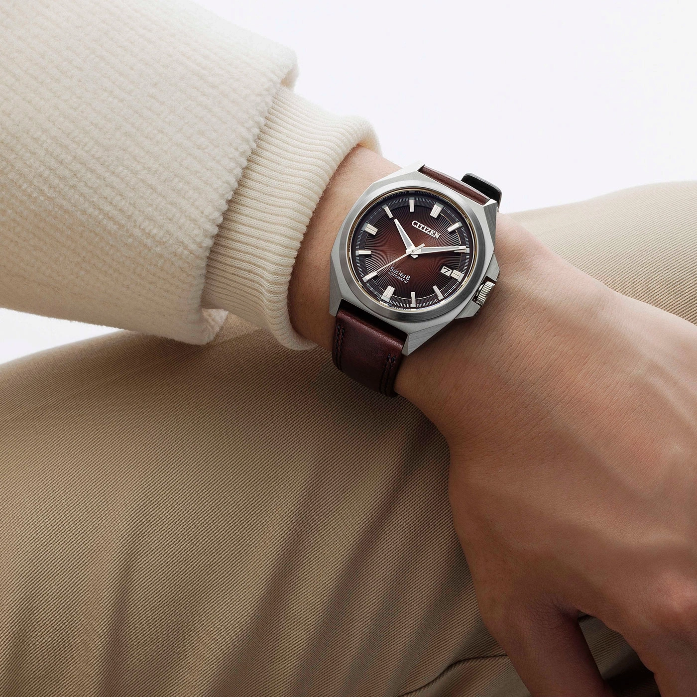 Citizen watch on wrist, brown leather strap, brown dial, beige clothing