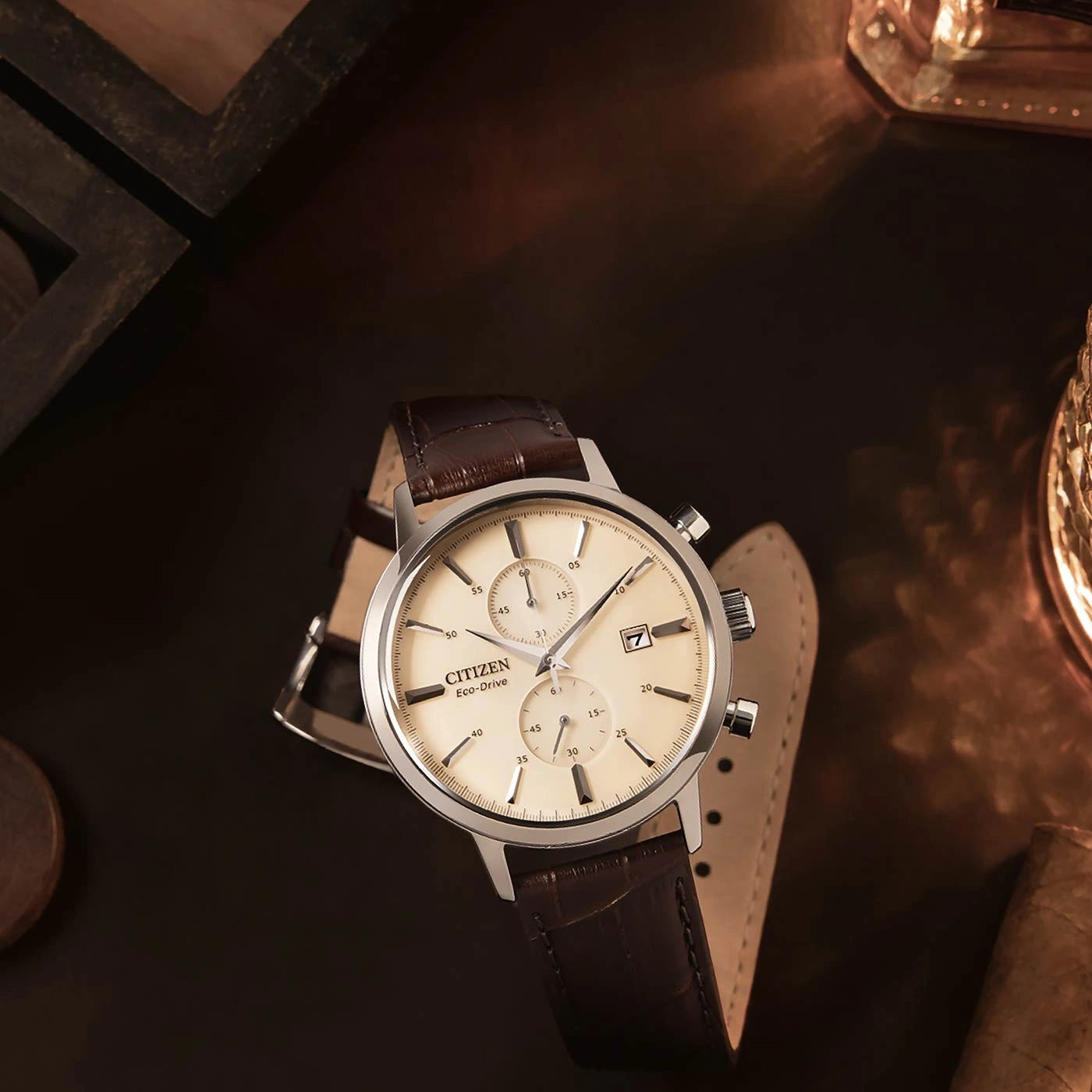 Citizen Eco-Drive watch with brown leather strap on a dark surface.