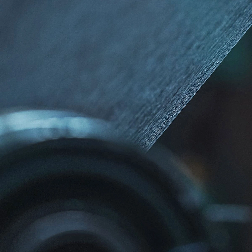Close-up of a textured, dark blue surface with blurred background and highlights.