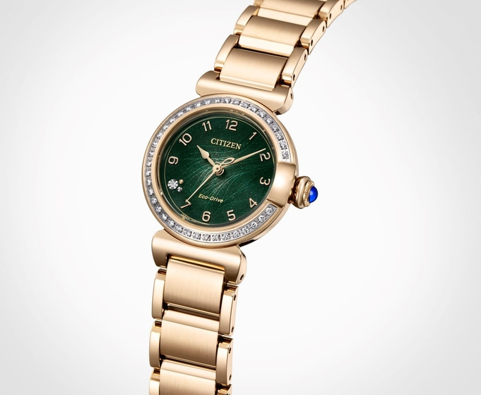 Gold Citizen watch with green face and diamond accents, elegant design.