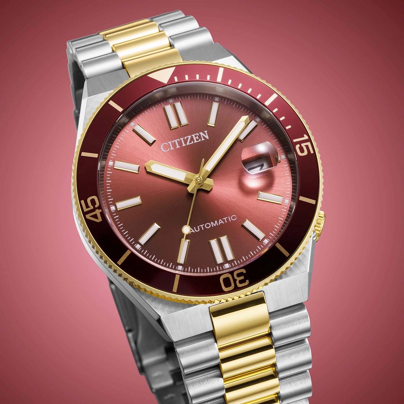 A close-up shot of a Citizen automatic watch with a red dial and gold accents.