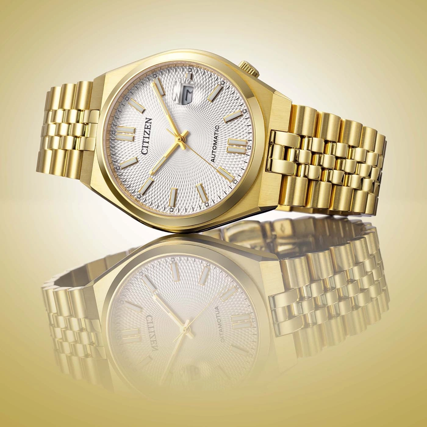 Gold Citizen watch with textured dial and bracelet, reflected.