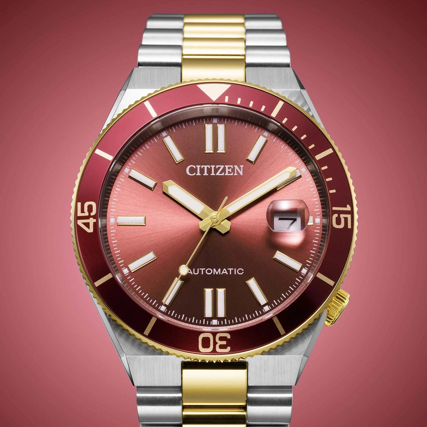 A close-up shot of a Citizen automatic watch with a red dial and gold accents.