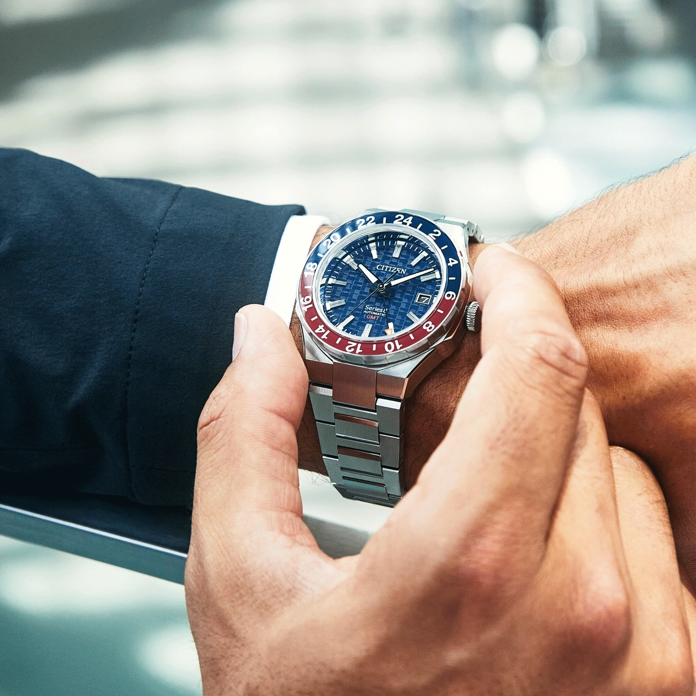 Man wearing a Citizen watch. Blue and red bezel. Stainless steel bracelet.