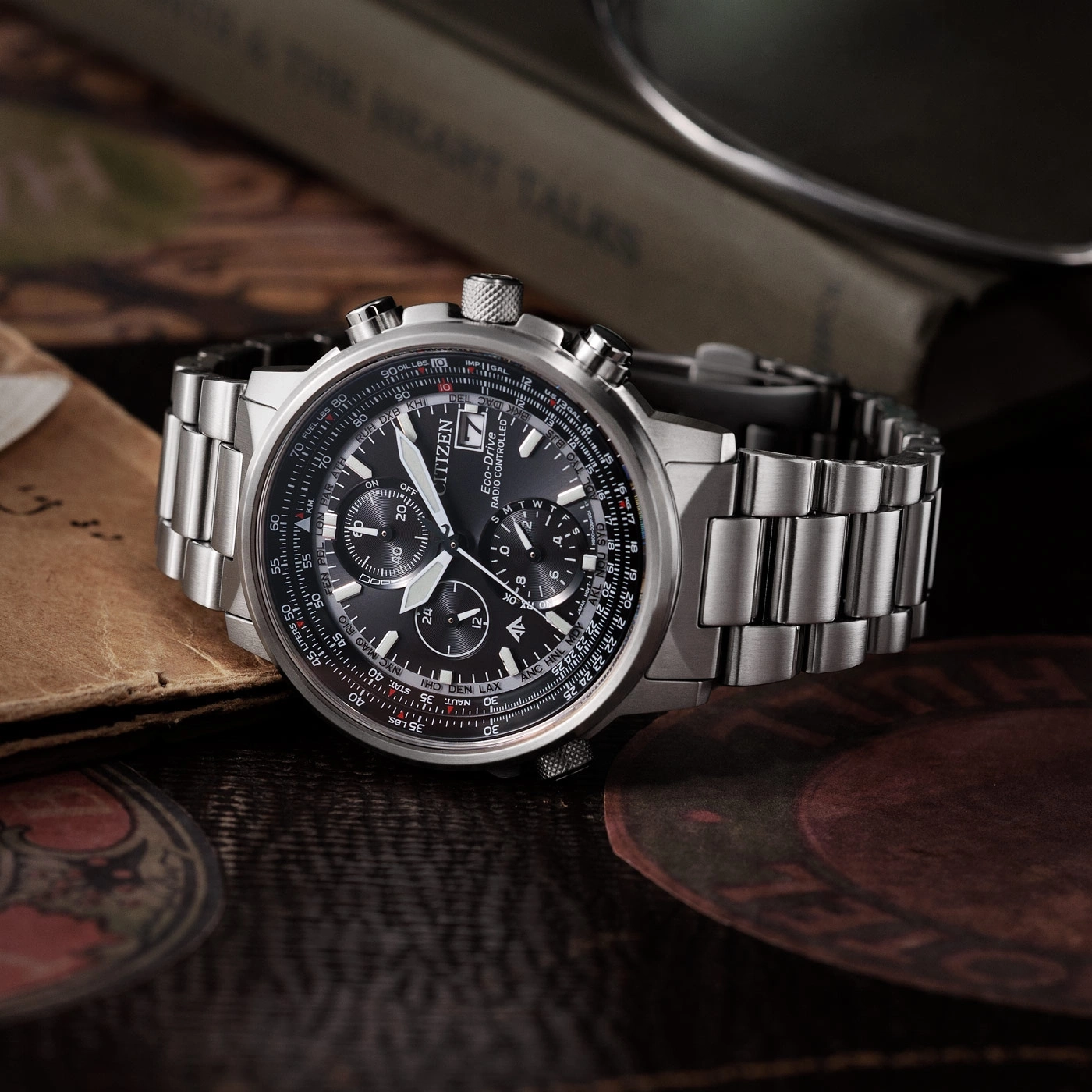 Citizen watch with black face and silver band on a wooden surface.