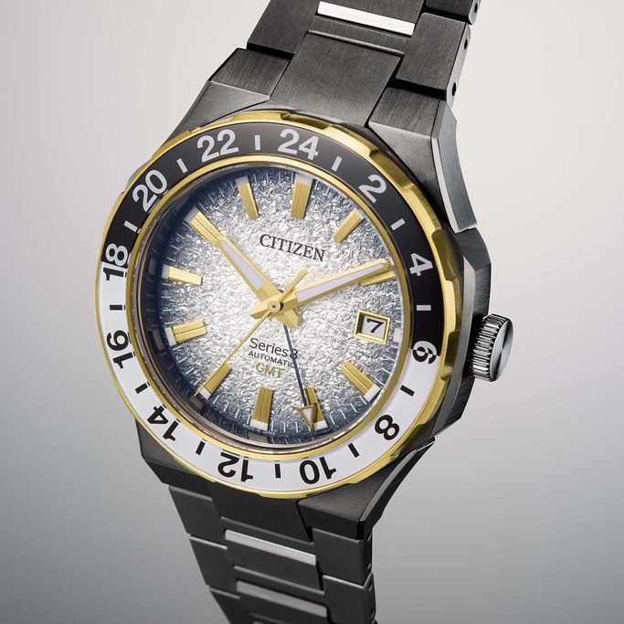 Citizen watch with gold accents, black bezel, and textured silver dial.