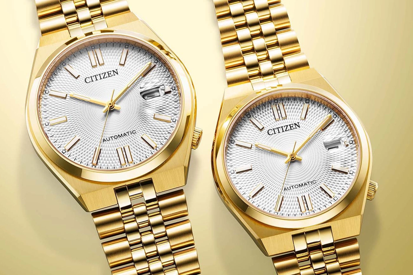 Two golden Citizen automatic watches with white textured dials.