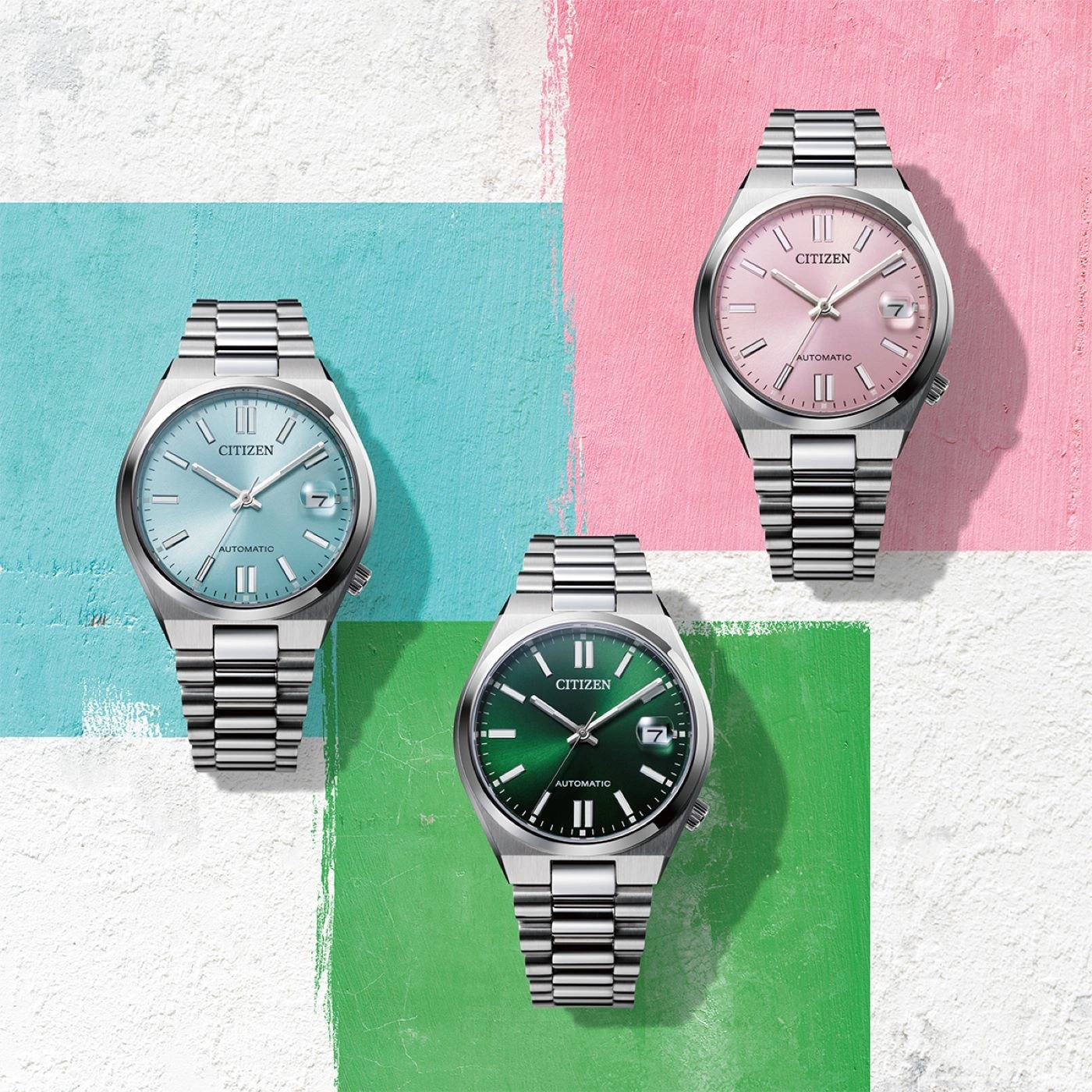 Three Citizen watches with different colored faces on a colorful background.
